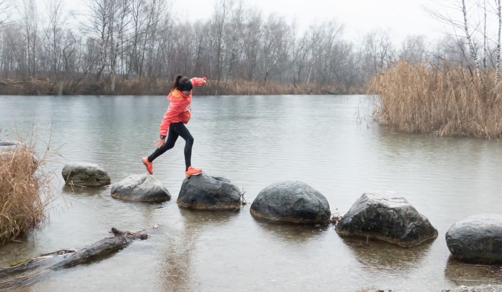 Samira balancieren auf den nassen Steinen